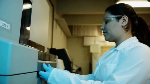 A handheld shot of a researcher checking a DNA sequencer a genetic laboratory at Stock Footage 97739265