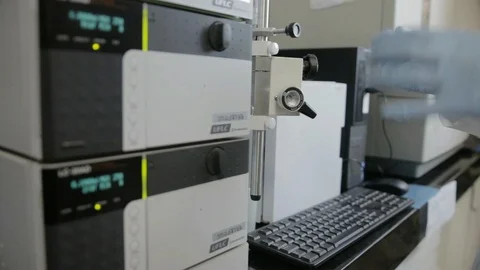 A handheld shot of a researcher checking a HPLC in a genetic laboratory at unive Stock Footage 97749023