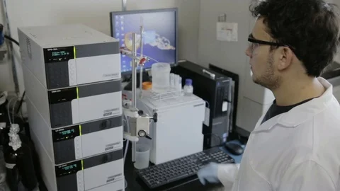 A handheld shot of a researcher checking a HPLC in a genetic laboratory at unive Stock Footage 97750313