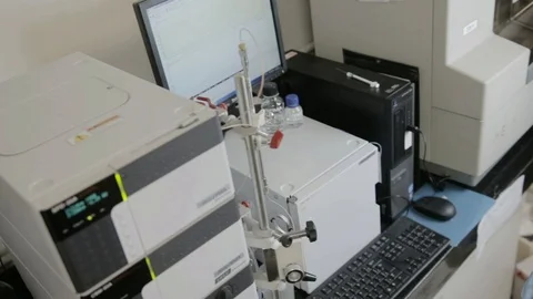 A handheld shot of a researcher checking a HPLC in a genetic laboratory at unive Stock Footage 97750667