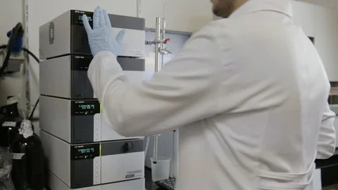 A handheld shot of a researcher checking a HPLC in a genetic laboratory at unive Stock Footage 97751348