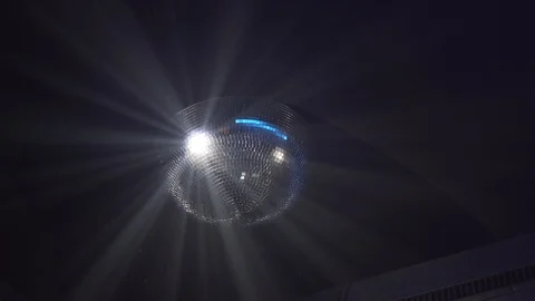 Handheld shot of shining disco ball hanging on ceiling Video stock 114876641