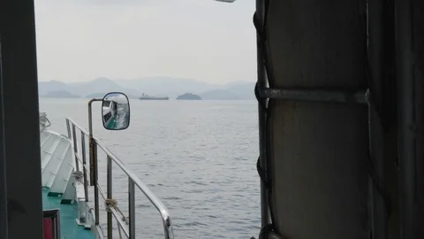 Handheld shot from ship cabin with view of sea and mountains on misty day, Japan Stock Footage 146142972