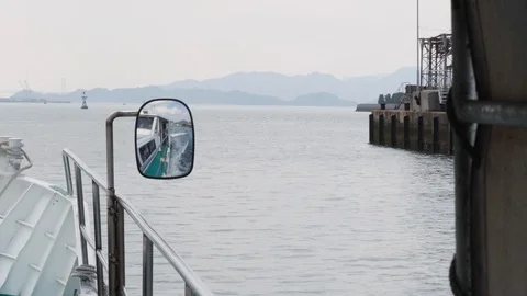 Handheld shot from ship cabin with view of sea and mountains on misty day, Japan Stock Footage 146143620