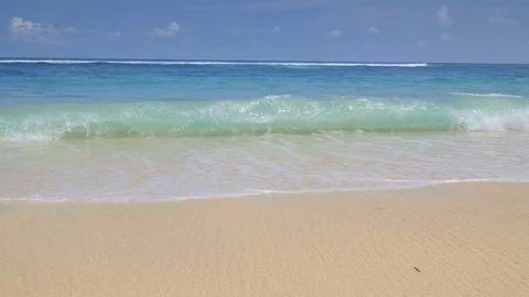 A handheld shot in slow motion of a sandy tropical beach with big waves Video stock 113507956