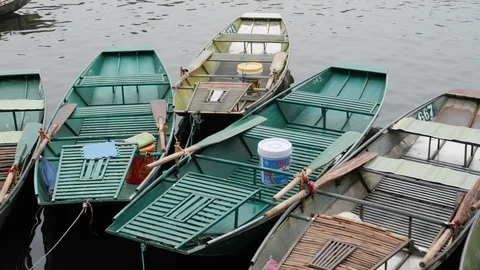 Handheld shot of small rowing boats swinging on top of water surface, Ninh Binh Stock Footage 147355580