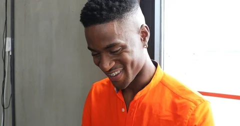 Handheld shot of smiling man talking on smart phone while sitting by window Stock Footage 120153668