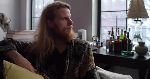 Handheld shot of thoughtful man looking away while sitting on sofa Stock Footage 114841590