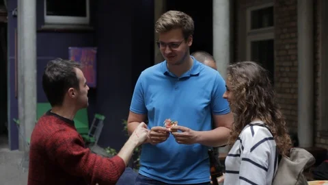 Handheld shot of three friends talking eating together Stock Footage 114847096