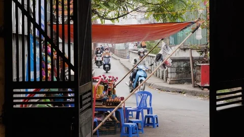 Handheld shot through open door of people riding scooters to travel across city Stock Footage 147367983