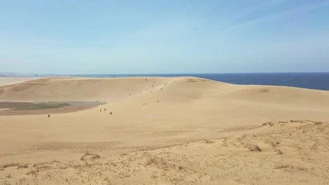 Handheld shot of Tottori Sand Dunes (Tottori Sakyu) in sunny day with blue sky Stock Footage