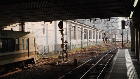 Handheld shot of train leaving train station with buildings in background, Japan Stock-Footage 146140521