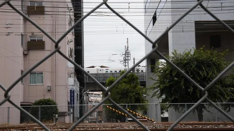 Handheld shot of train passing on bridge with buildings in foreground, Kyoto Stock Footage 146138144