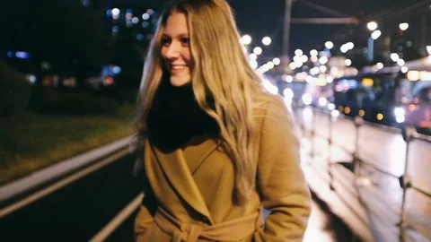Handheld shot of two beautiful young women talking on city street at night Stock Footage 122513280