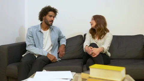 Handheld shot of two colleagues talking while sitting on sofa in slow motion Stock Footage 114872077