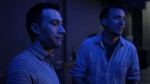 Handheld shot of two men dance and chat against wall in nightclub 스톡 동영상 114847882