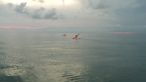 Handheld shot of two men kayaking as the sun is setting Stock Footage 310540019