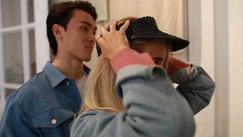 Handheld shot of two people trying out a cap in the store Video stock 114886065