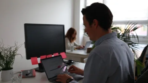 Handheld shot of two people working at office 스톡 동영상 120426176