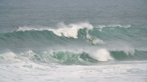 Handheld shot of two professional surfers in ocean on jet ski and surfing board Video stock 158651937