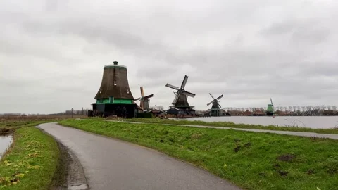 Handheld Shot of typical Dutch Windmills of Zaanse Schans spinning in the wind. Video stock 168225557