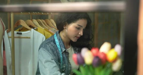 Handheld shot, view through clear glass, Young female fashion designer  Stock-Footage 226491107