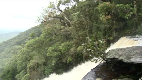 Handheld shot of a waterfall in the middle of a forest Stock Footage 310541133