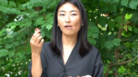 Handheld shot of woman eats fruit pastry outdoors Video stock 114849801