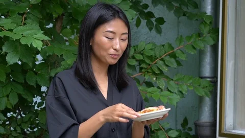 Handheld shot of woman eats fruit pastry outdoors Video stock 114849815