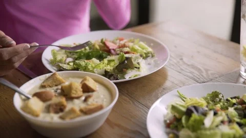 Handheld shot of woman having food at table in restaurant Stock Footage