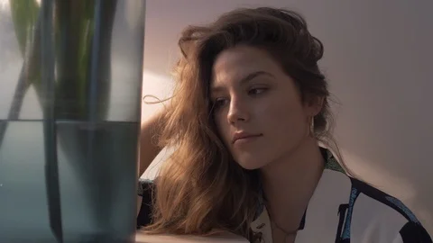 Handheld shot of woman posing while sitting on the couch in front of glass vase Vídeo Stock 114842527