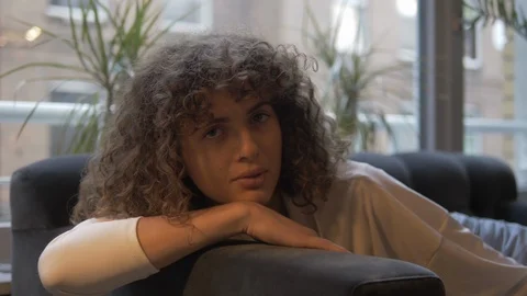 Handheld shot of woman posing while sitting on the couch Stock-Footage 114842565