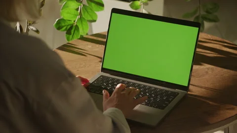 Handheld shot of a woman single scroll on a laptop computer with green screen Stock Footage 208367482
