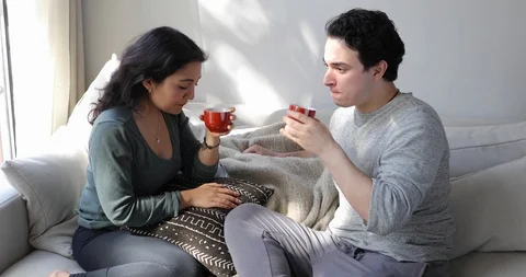 Handheld shot of young couple drinking coffee and talking while sitting Video stock 120424593