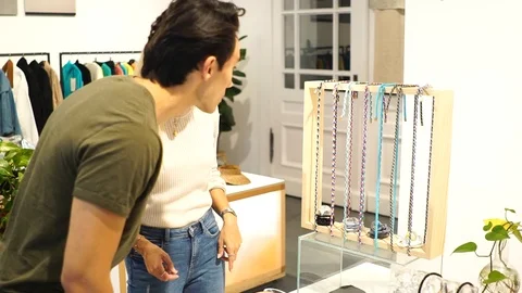 Handheld shot of young couple having conversation about eyeglass chains in shop Video stock 114884200