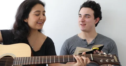 Handheld shot of young couple learning to play guitar Stock Footage 120456002