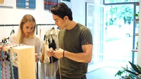 Handheld shot of young couple talking while browsing items in shop 스톡 동영상 114884298