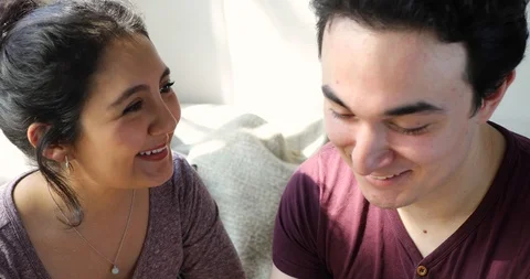 Handheld shot of young couple talking and smiling while sitting together Stock Footage 120425509