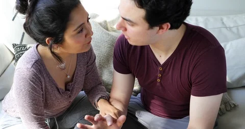 Handheld shot of young couple talking and using tablet while sitting together Stock Footage 120427231