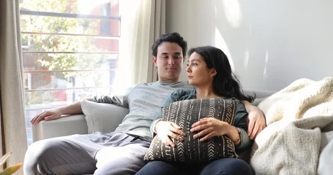Handheld shot of young couple talking while sitting on sofa at home Video stock 120430551