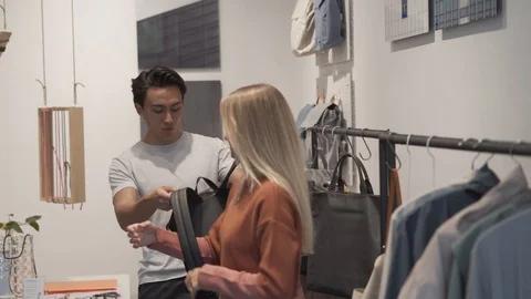 Handheld shot of young couple trying on backpack at store Stock Footage 114875701