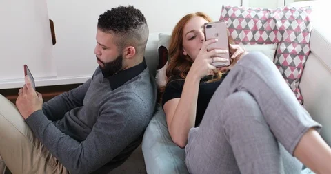 Handheld shot of young couple using smartphone in living room Stock Footage 119758808
