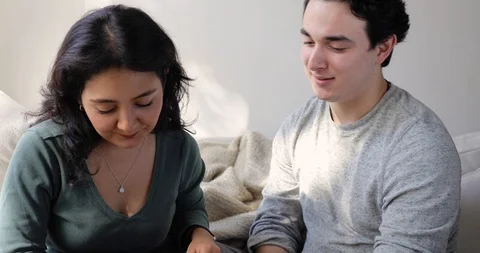 Handheld shot of young couple using smart phone together and talking at home Stock Footage 120428500