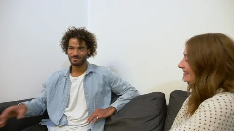 Handheld shot of young creative colleagues talking while sitting on sofa 스톡 동영상 114872135