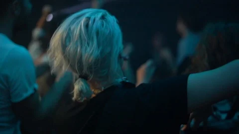 Handheld shot of young friends dancing in a group in a night club Video stock 114877826