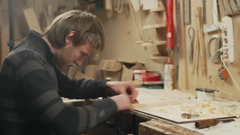 Handheld shot young joiner working with piece of wood in workshop Stock Footage 155618097