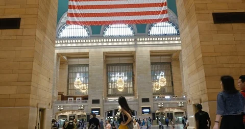 Handheld shot of young lady with backpack looks around inside of central station Stock Footage 120133137