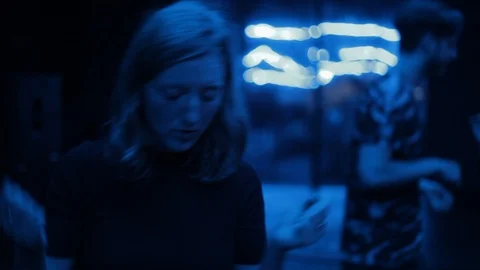 Handheld shot of young lady dances in dark nightclub environment Stock Footage 114848045