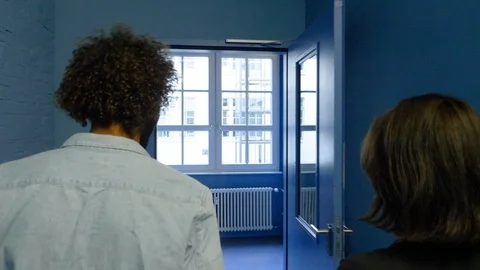 Handheld shot of young man and woman walking in the corridor of office 스톡 동영상 114872002