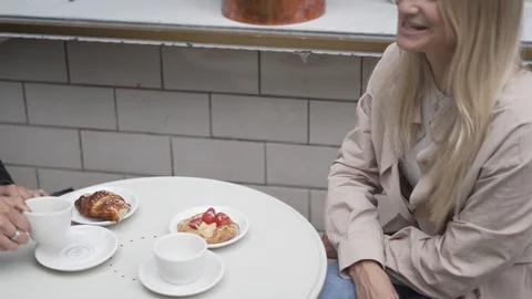 Handheld shot of young man and young woman sitting in sidewalk cafe Stock Footage 114875596